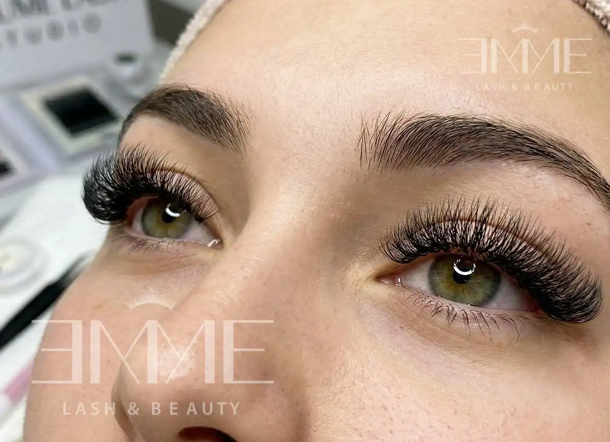 Volume eyelashes extensions result at EMME Lash & Beauty showing full, dark, fluffy lashes on green eyes